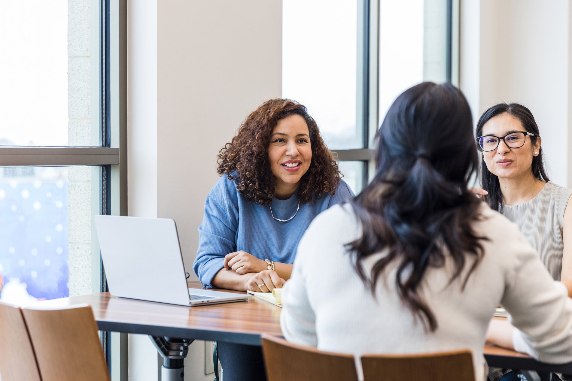 Young adult businesswomen meet with the unrecognizeable woman to begin their mentorship program